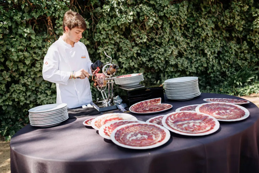 Cortador de jamón en un evento al aire libre con los platos listos para servir